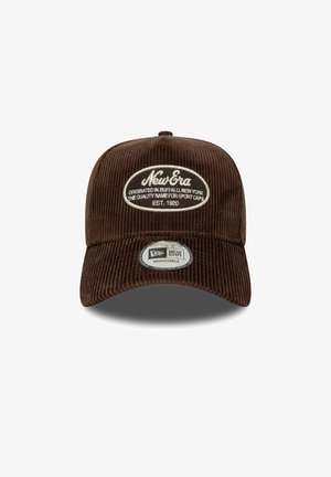 Braune Cordhut mit runder Krone und verstellbarem Riemen. Mit einem weißen ovalen Patch mit "New Era" und Logo sowie einem runden Etikett.