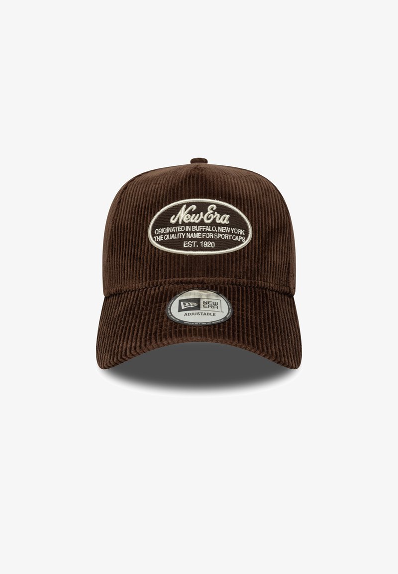 Brun saum stoff caps med rund krone og justerbar stropp. Har en hvit oval lapp med "New Era" og logo, samt et rundt merke.