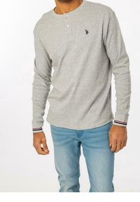 Szara długa koszulka henley z długim rękawem i trzema guzikami przy dekolcie. Posiada paskowe akcenty przy mankietach oraz małe logo na piersi.