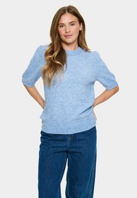 Kurzärmliger, hellblauer Pullover aus weichem Material, mit Rundhalsausschnitt und geripptem Saum, kombiniert mit blauen Jeans.