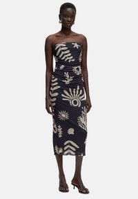 Marineblaues trägerloses Kleid mit beigen Blumen- und Blättermustern, das eine figurbetonte Silhouette und Raffungselemente aufweist.