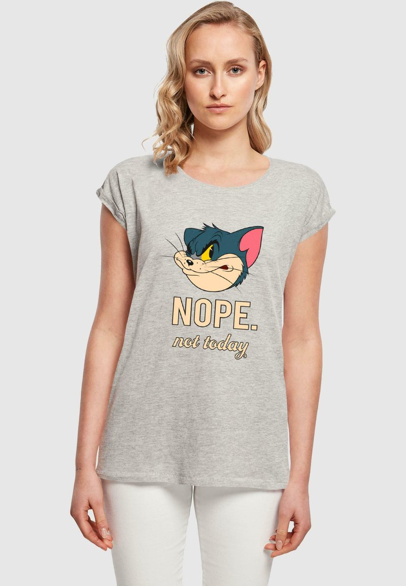Grijze t-shirt met het gezicht van een cartoonkat in een blauw en roze ontwerp, met daaronder de tekst "NOPE. niet vandaag." Vloeiende pasvorm met opgerolde mouwen.