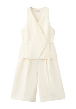 Veste sans manches écrue à nouer sur le côté, associée à un pantalon culotte large assorti.