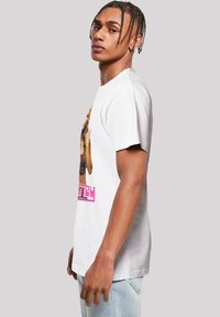 Witte katoenen t-shirt met een grafisch ontwerp van een vrouw en de tekst "Disney" in het roze. Korte mouwen, ronde hals, relaxed fit.