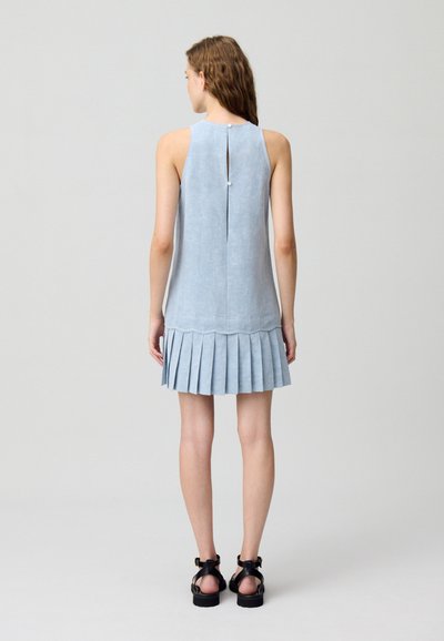 Robe sans manches bleu clair avec une jupe plissée, fermeture à boutons dans le dos et texture lisse, mettant en valeur un design simple et élégant.