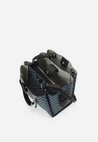 Strukturalna torebka na ramię z geometrycznym wzorem w odcieniach niebieskiego i czerni, z teksturowanymi skórzanymi akcentami, podwójnymi uchwytami oraz zamykaną na zamek przegrodą wewnętrzną.