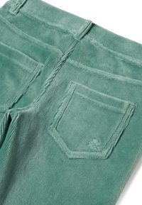 Zelené manšestrové kalhoty s zadní kapsou s vyšitým detailem, texturovaným povrchem a viditelným švem podél okrajů.