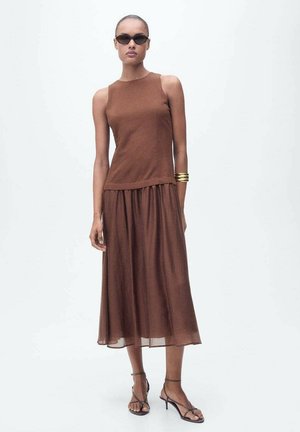 Brown sleeveless top paired with a matching flowy skirt. Sheer texture, simple design, and minimalistic accents complement the look.