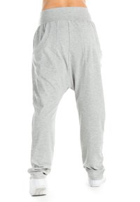 Lichtgrijze joggers met een brede elastische tailleband, twee zijzakken en taps toelopende boorden bij de enkels, gemaakt van zachte, ademende stof.