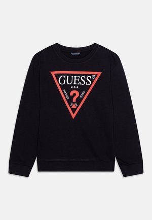 Sweatshirt noir avec un col rond, arborant un logo triangulaire rouge qui comprend le texte "GUESS U.S.A." et des symboles.