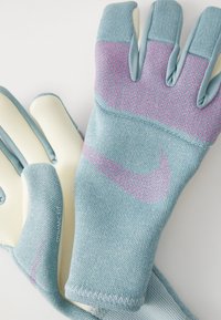Guanti azzurri chiari con un tessuto a maglia testurizzata, caratterizzati da accenti rosa e un grande logo. Il design include fessure separate per le dita per una maggiore destrezza.