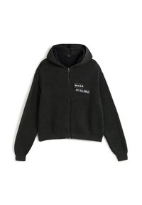 Musta ribbed vetoketjuhuppari, jossa on edessä "Vans Off The Wall" -logo ja pitkät hihat valkoisella taustalla.