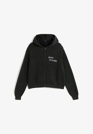 Czarna, prążkowana bluza z kapturem na zamek błyskawiczny z przodu z naszywką "Vans Off The Wall" i długimi rękawami na białym tle.