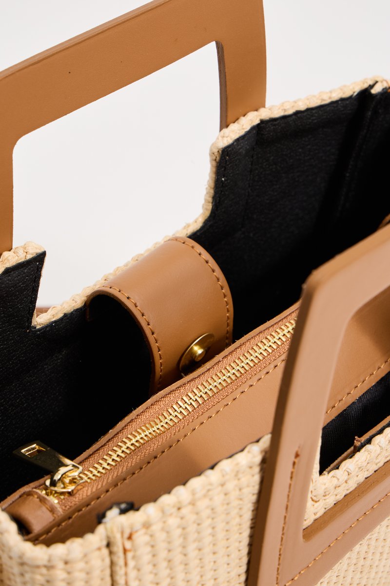 Geweven leren tas van stro met tan lederen accenten, rechthoekige vorm, bovenhandvatten, binnenzak met rits en zwarte voering.