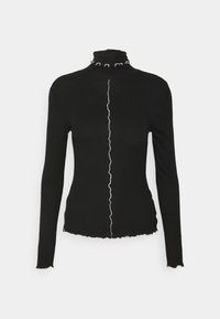 Svart långärmad polotröja med en böljande vit söm ner i mitten och vågiga kanter vid kragen och nederkant, tillverkad av ett elastiskt material.