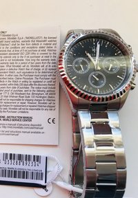 Silverfärgad klocka i rostfritt stål med en mörkgrå urtavla, tre subdials, självlysande visare, texturerad bezel och ett polerat armband.