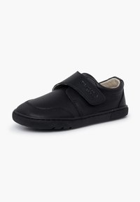 Chaussure noire pour enfant avec semelle en caoutchouc texturée, bande velcro et doublure intérieure beige douce, présentée sur fond blanc.