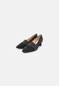 Black suede pointed-toe heels with a wide fabric band across the midfoot and a low block heel. Smooth texture and minimalist design.