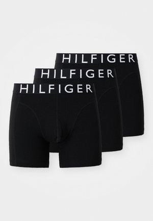 Três cuecas boxer pretas para homem com cintas brancas com a marca "HILFIGER", dispostas sobrepostas num fundo branco.