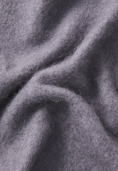 Šviesiai pilka, minkšta medžiaga su pūkuota tekstūra, rodanti subtilius storio pokyčius ir raukšlėtą išvaizdą paviršiuje.