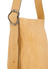 Sac à épaule en cuir tan avec une surface lisse, des accessoires métalliques arrondis et des coutures. Il dispose d'une large bandoulière réglable.