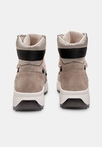 Bottes avec une tige en suède gris et textile beige, dotées d'un col rembourré, d'une sangle noire et d'une semelle extérieure en caoutchouc blanc avec un relief texturé.