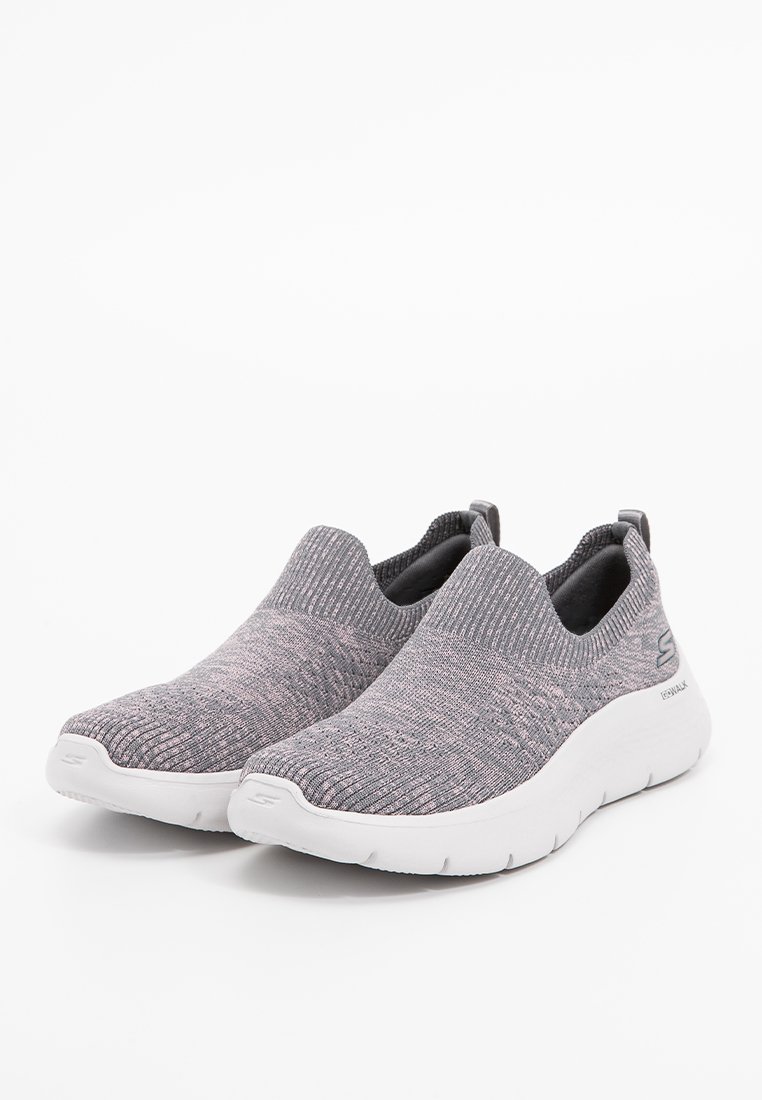 Schlüpfschuhe für den Sport aus strukturiertem grauem Strickstoff, mit einer weißen gepolsterten Sohle und dezenten rosa Akzenten.