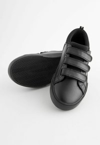 Zwarte leren schoenen met drie klittenbandsluitingen, ronde neus en een geprofileerde rubberen zool met een visgraatpatroon.