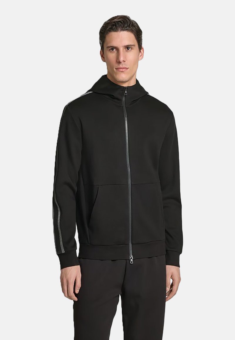 Felpa nera con zip realizzata in tessuto liscio, dotata di tasca a marsupio, polsini aderenti e strisce a contrasto lungo le maniche.