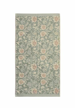 Alfombra floral verde con flores blancas y rosas y hojas, bordeada por franjas verdes estrechas sobre un fondo blanco.
