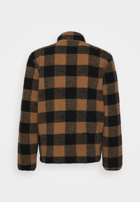 Casaco de polar xadrez marrom e preto com mangas longas e gola alta, visto de costas.