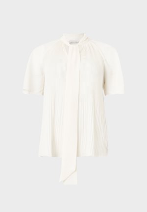 Blouse blanche à manches courtes avec des plis verticaux, un col montant et un long foulard noué à l'avant.