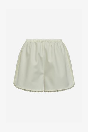 Shorts en satin couleur crème avec taille élastique et bordure en dentelle festonnée sur les côtés et à l'ourlet.