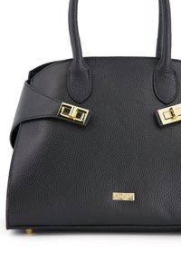 Sac à main en cuir noir avec finition texturée, double poignées et accents en métal doré. Équipé d'une bandoulière avec des boucles décoratives.