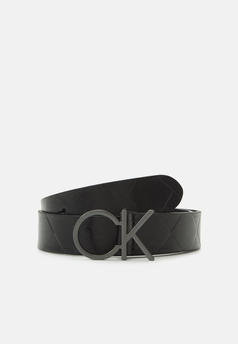 Ceinture en cuir noir avec motif matelassé et boucle en métal foncé en forme des lettres "cK" en minuscules et majuscules.