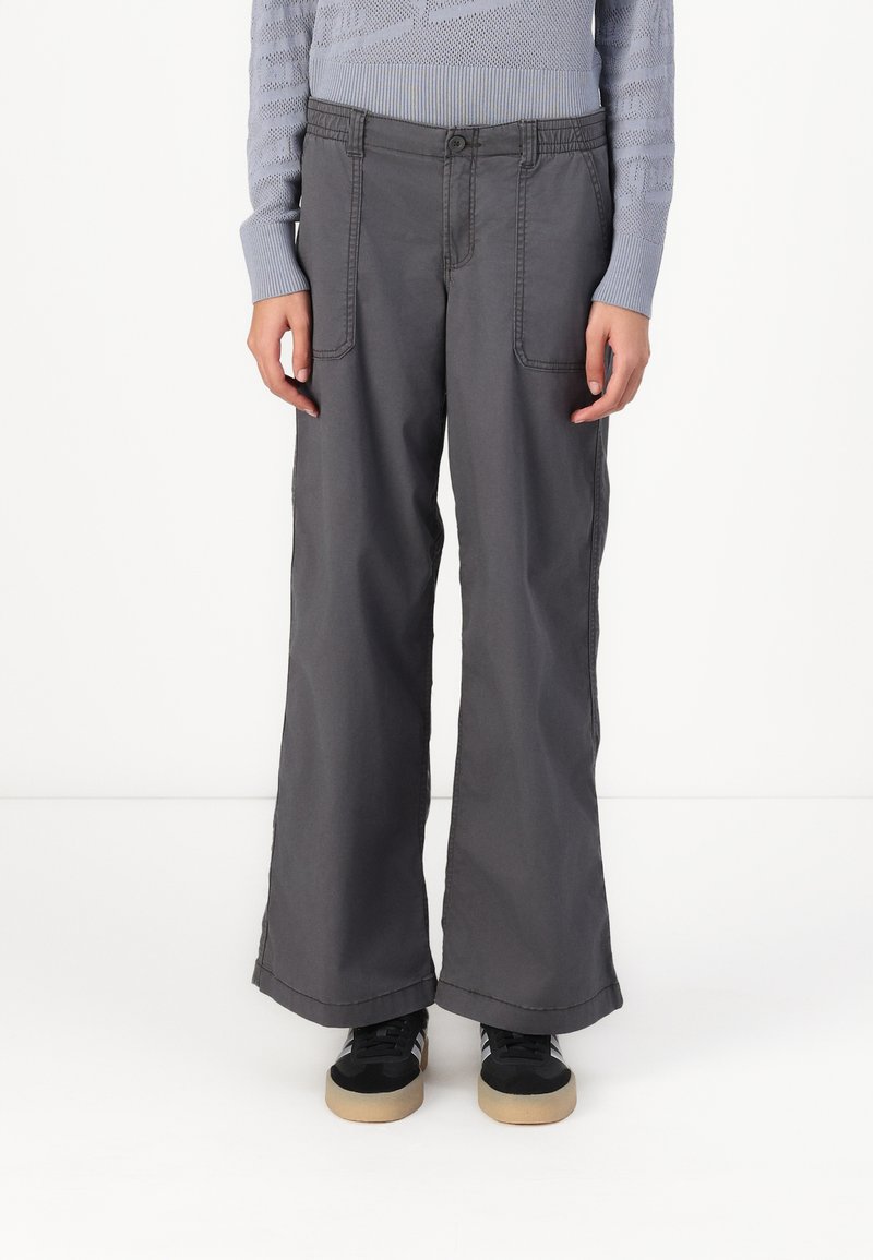 Gray wide-leg pants made of cotton with visible stitching, two front pockets, and a relaxed fit. Paired with black sneakers.