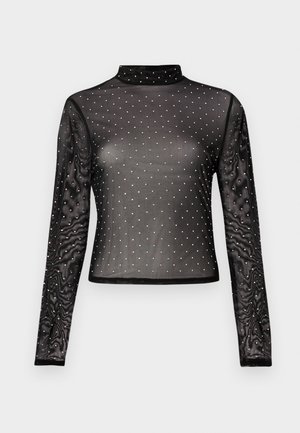 Melnā garroku blūze no caurspīdīgas auduma ar imitēto augstu apkakli, rotāta ar daudzkrāsainiem fliteriem punktiņveida rakstā.