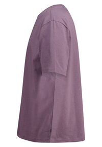 Violetti puuvillainen t-paita lyhyillä hihoilla, rento malli ja kaareva helma. Sileä pinta; sivuaukko yksityiskohtana helman lähellä.