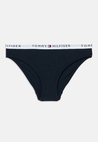 Tumesinine puuvillane bikiinipüksik valge elastse vöörihmaga, millel on "TOMMY HILFIGER" logo ning punane ja sinine aksent.