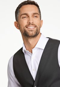 Gilet nero sopra una camicia bianca con bottoni. Il gilet presenta una texture liscia e la camicia ha un colletto standard. Lo sfondo è di un bianco semplice.