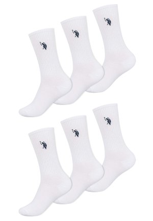 Sechs weiße Crew-Socken mit geripptem Bündchen und kleinen schwarzen Polospieler-Logos an den Seiten, angeordnet in zwei Reihen auf weißem Hintergrund.