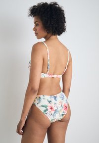Blomsterbikini-set med pastellfarger, justerbare stropper og en høy midje-bunn med et livlig hibiskus- og bladmønster.