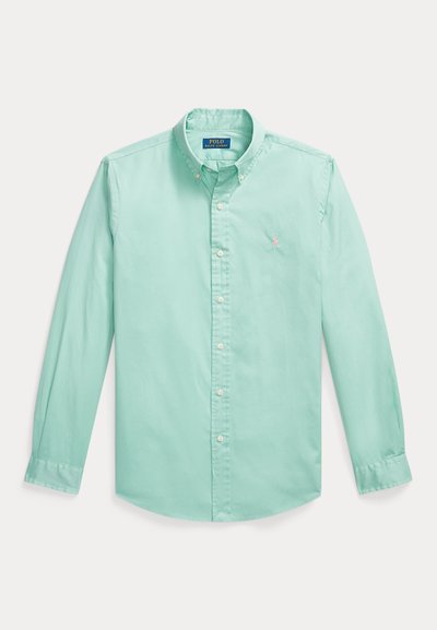 Πουκάμισο μέντας με μακριά μανίκια, κουμπώνει με κουμπιά και έχει γιακά που κλείνει με κουμπί, με μικρό κεντημένο λογότυπο στο αριστερό μέρος του στήθους.