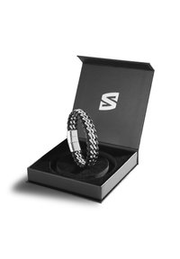 Black and silver chain bracelet displayed in a black box with velvet lining, featuring a sleek clasp and geometric design.