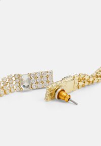 Aukso spalvos apyrankė su skaidriais rhinestones akmenimis tinklo raštu, glotnais metaliniais akcentais ir smeigtuko užsegimo mechanizmu.