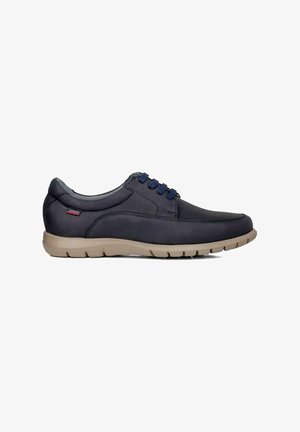 Scarpa blu navy realizzata in materiale liscio, con punta arrotondata e suola in gomma beige. Presenta dettagli in pizzo blu e una fodera interna grigia.