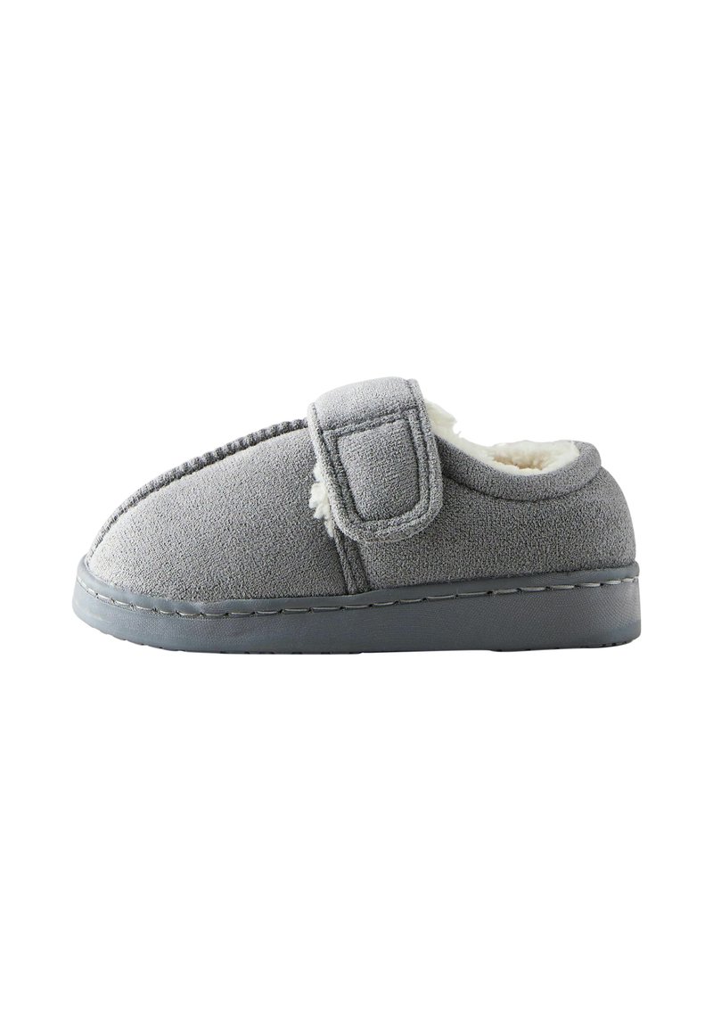 Chausson gris avec une bande velcro, fabriqué en tissu doux, doté d'un intérieur douillet et d'une semelle en caoutchouc plate.