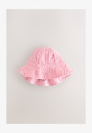 Cappello a secchiello rosa chiaro realizzato in tessuto morbido e strutturato. Presenta una tesa larga e una piccola etichetta con un disegno a forma di cuore sul lato.