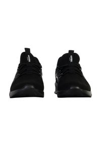 Chaussures de sport noires avec une tige en tricot, présentant un design à lacets, des accents texturés et une languette au talon. Semelle en caoutchouc avec un profil de sculpture minimal.