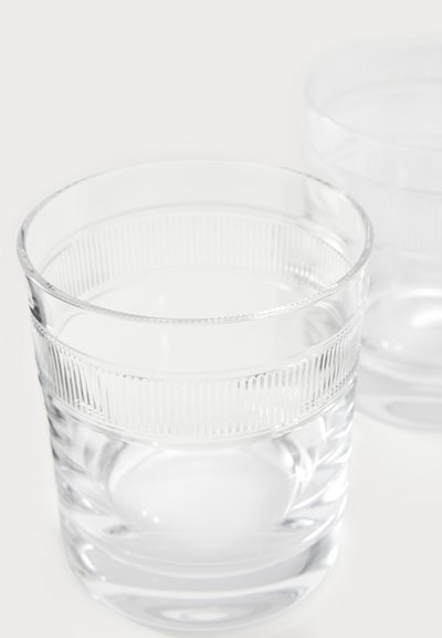 Prozorni stekleni kozarci za pitje z rebrasto teksturo na zgornjem delu in gladko osnovo, ki poudarjajo prozoren videz in elegantno obliko.